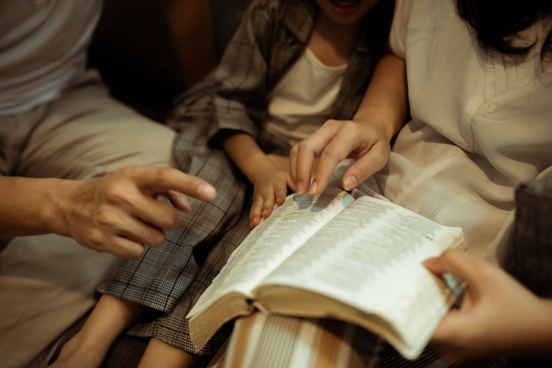 famille asiatique priant et lisant la bible ensemble à la maison